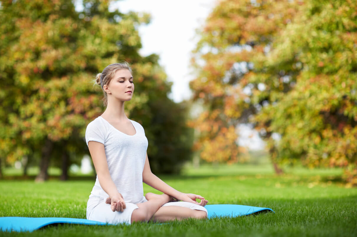 a woman doing yoga in a flat area with lots of grass